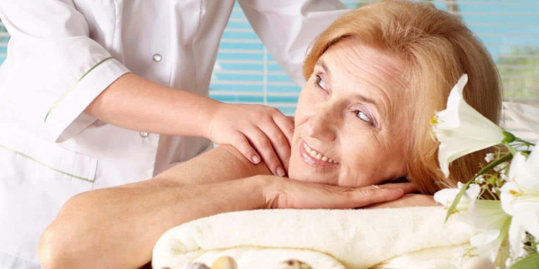 An Elder Woman Relaxing While Massage Therapy By A Experienced Massage Therapist.