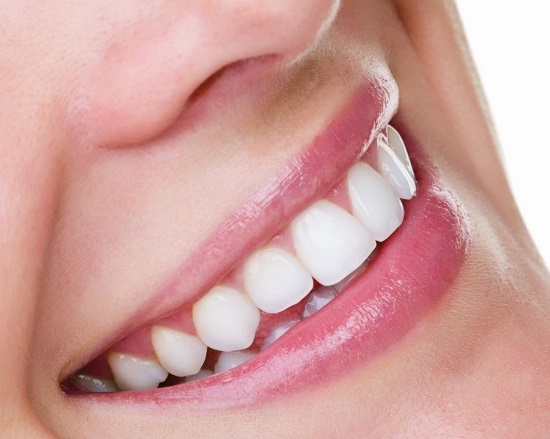 Close up shot of a woman who is seen smiling broadly.