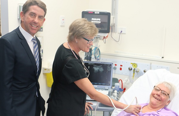 A elderly women being checked by two doctors